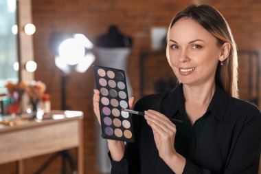 Profesyonel makyöz stüdyoda göz farı sürüyor.