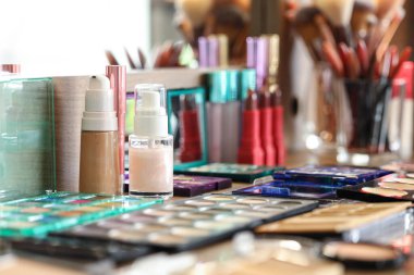 Stüdyoda makyaj sanatçılarının masasında çeşitli dekoratif kozmetik ürünleri var.