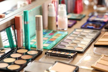 Stüdyoda makyaj sanatçılarının masasında çeşitli dekoratif kozmetik ürünleri var.