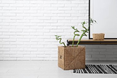 Hasır sepetin içinde masa ve bambu saplı şık bir oturma odası.