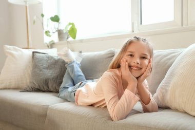 Küçük kız evde koltukta yalan