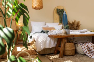 Yatak odasının içinde sörf tahtası ve ahşap bank var.