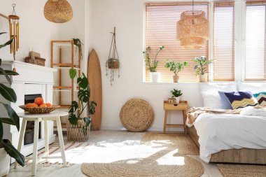 Sörf tahtası, bitkileri ve şöminesi olan aydınlık yatak odasının içi