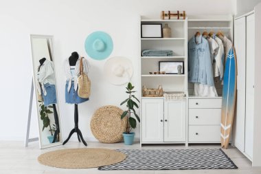 Sörf tahtası, dolap ve mankenli aydınlatma odasının içinde.