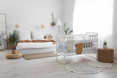 İçinde yatak, bebek karyolası ve lambalar olan bir oda.