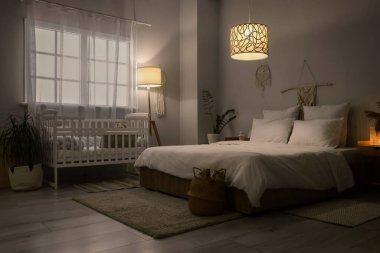 İçinde yatak, bebek beşiği ve parlayan lambalar olan karanlık bir oda.