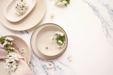 Beyaz arka planda çiçek açan dalları olan temiz bej plakalar