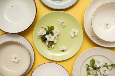 Sarı arka planda çiçek açan dalları olan farklı temiz tabakalar.