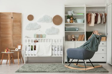 Bebek beşiği, dolabı ve sallanan koltuğu olan ışık kreşinin içinde.