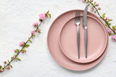 Beyaz arka planda pembe çiçek açan dalları olan güzel masa ayarları