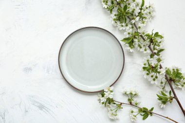 Beyaz arkaplanda çiçek açan dalları olan güzel masa ayarları