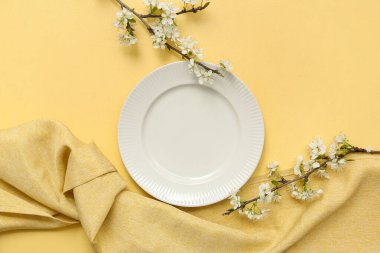 Sarı arka planda çiçek açan dalları olan güzel masa ayarları