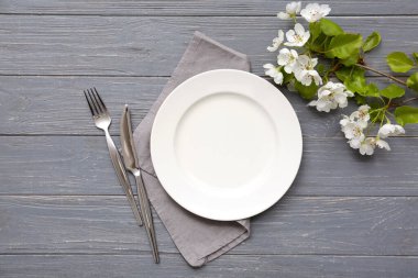 Gri ahşap arka planda çiçek açan dallarıyla güzel bir masa.