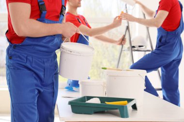 Odada bir kova boyası olan erkek dekoratör.