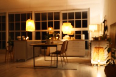 Mutfak manzarası bulanık tezgahlar, yemek masası ve geceleri parlayan lambalar