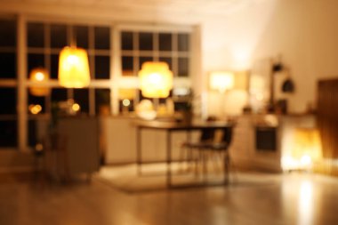 Mutfak manzarası bulanık tezgahlar, yemek masası ve geceleri parlayan lambalar