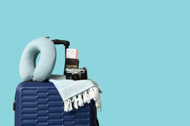 Bavul, seyahat yastığı, fotoğraf makinesi, pasaport ve renkli arka plan bileti