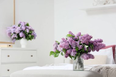 Vazodaki yumuşak bankta leylak çiçekli vazo.