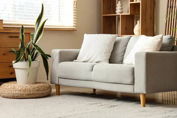 Kanepe, puf ve çiçekli rahat bir oturma odası.