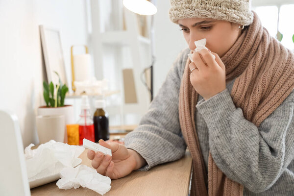 Sick woman with cito test sneezing at home