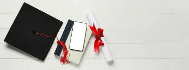 Mezuniyet şapkası, kitap, cep telefonu ve beyaz ahşap zemin üzerine diploma metin için alan, üst görünüm