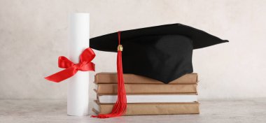 Beyaz arka planda kitap yığını ve diploması olan havan topu tahtası