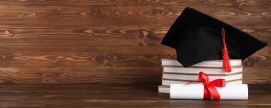 Havan tahtası, kitap yığını ve ahşap arkaplan üzerine diploma.