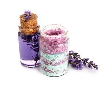 Beyaz arka planda bir şişe lavanta yağı ve deniz tuzu.