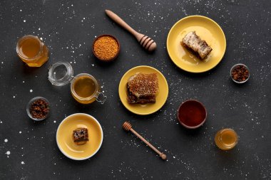 Tatlı bal, taraklar ve siyah arkaplanda arı poleni