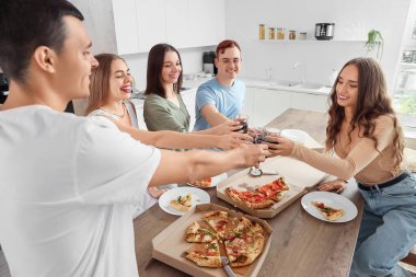 Pizzalı bir grup genç arkadaş ev partisinde içki içiyor.