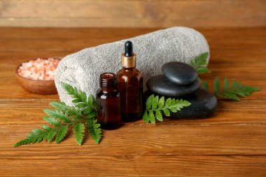 Ahşap zemin üzerinde bitki yaprakları olan spa kompozisyonu