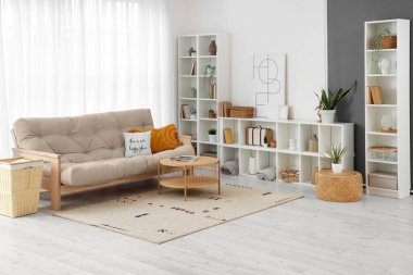 Posteri, raf ünitesi ve kanepesi olan şık bir oturma odası.