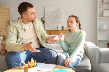 Baba, kızının ev ödevlerine yardım ediyor.