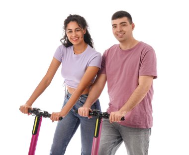 Beyaz arka planda modern elektrikli scooterları olan güzel genç bir çift.