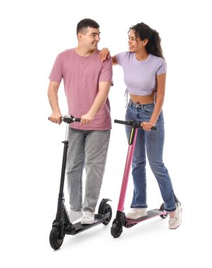 Beyaz arka planda modern elektrikli scooterları olan güzel genç bir çift.