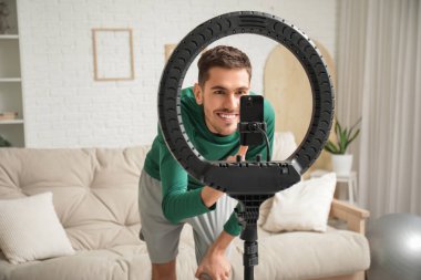 Spor düşkünü erkek blogcu evde video kaydediyor.