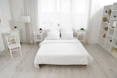 Masaları ve penceresi olan aydınlık yatak odasının içi