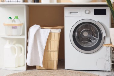 Çamaşır odasındaki çamaşır makinesinin yanındaki tahta sepet.