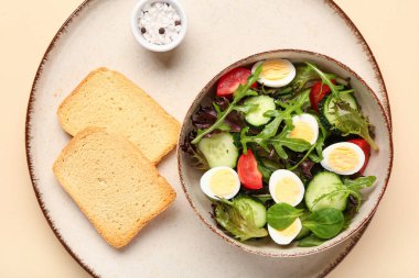 Kaynamış bıldırcın yumurtalı bir kase lezzetli salata, arka planda deniz tuzu ve tost, yakın plan.