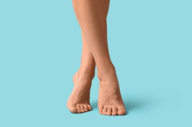 Mavi arka planda genç bir kadının bacakları