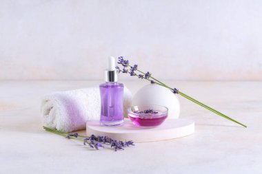 Havlu, alçı standı, şişe ve bir kase hafif arka planda gerekli lavanta yağı.