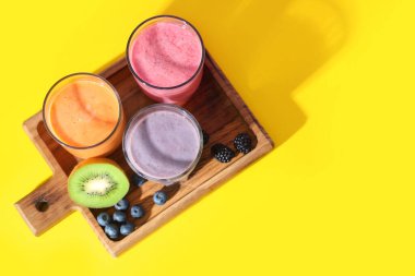 Sarı arka planda farklı böğürtlenli taze meyve püresi.