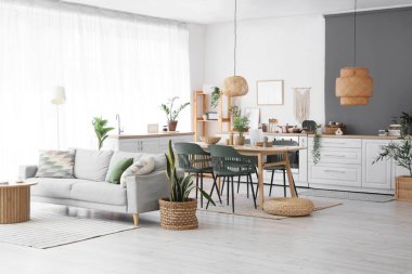 Koltuğu, masası ve hasır pouf 'u olan hafif yemek odasının içi.