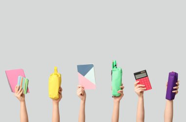 Beyaz arkaplanda farklı kırtasiye malzemesi olan kadın elleri