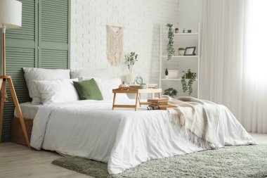 Yatak odasının içinde kahvaltı ve yatağın üstünde kitaplar.