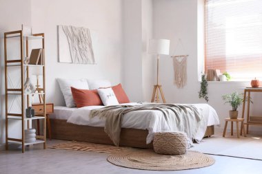 Rahat yataklı, komodinli, lambalı ve raflı modern yatak odası.