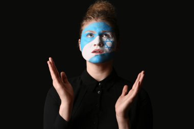 Yüzünde İsrail bayrağı olan dua eden genç bir kadın. Uluslararası Soykırım Anma Günü