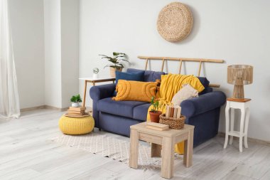 Oturma odasında rahat bir kanepe, sehpa ve puf.