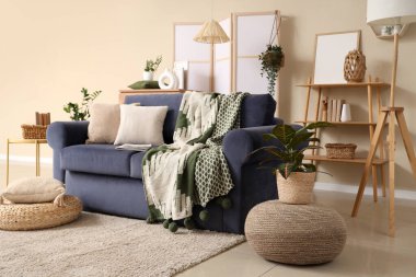 Oturma odasının içinde rahat bir kanepe ve puf.