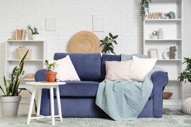 Oturma odasının iç tarafındaki çiçekli rahat bir kanepe ve kahve masası.